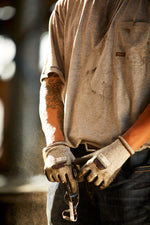 closeup of male worker safety gloves holding safety glasses at a construction site