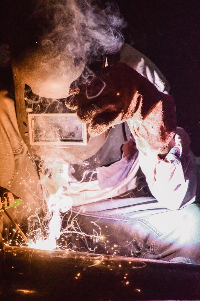 PPE safety gear being used as sparks fly at a construction site